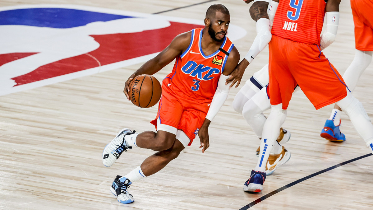 Chris Paul dribbles past defenders